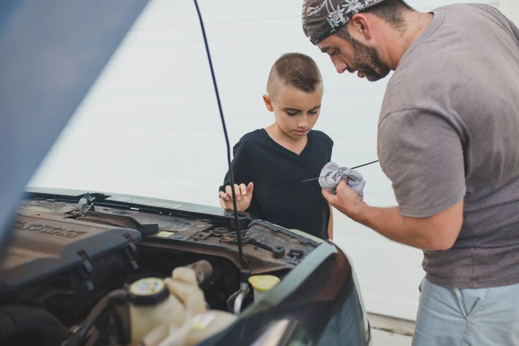 Father and son changing oil together.