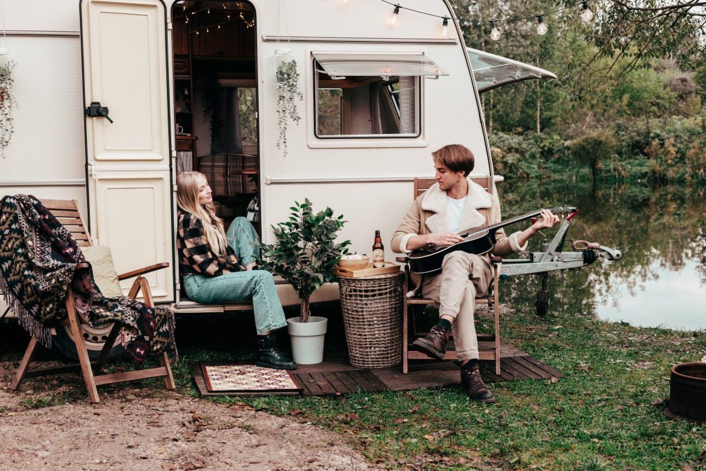 Couple sitting in front of lightweight travel trailer