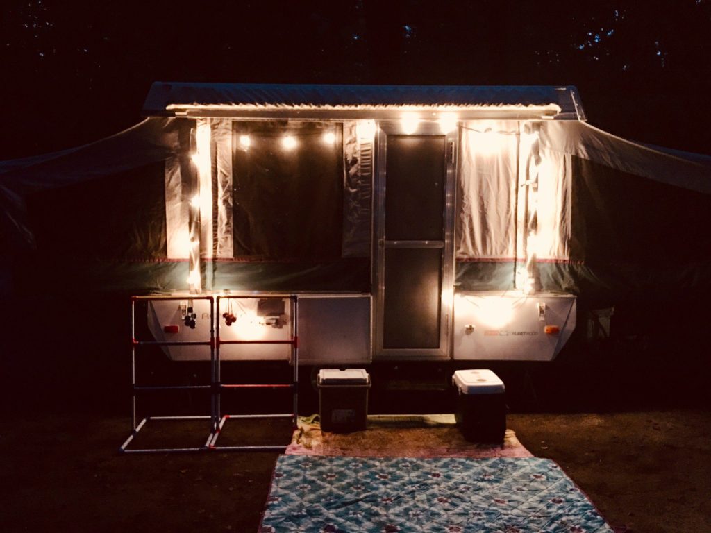 Pop-up camper parked at night.