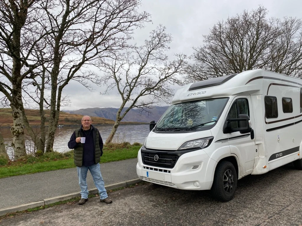 Senior man standing in front of RV