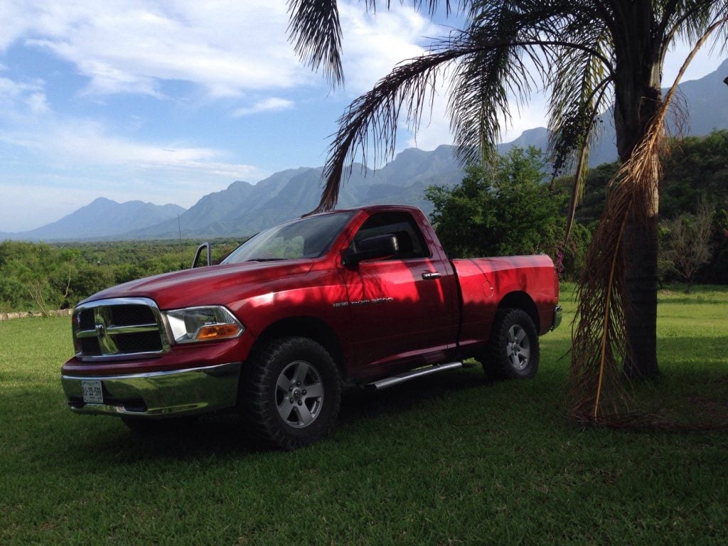 Red RAM truck parked on grass.