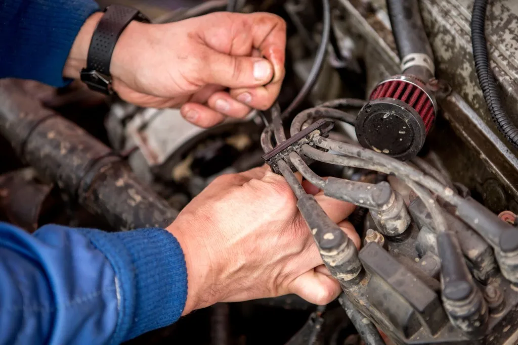 Mechanic repairing electrical system in vehicle.