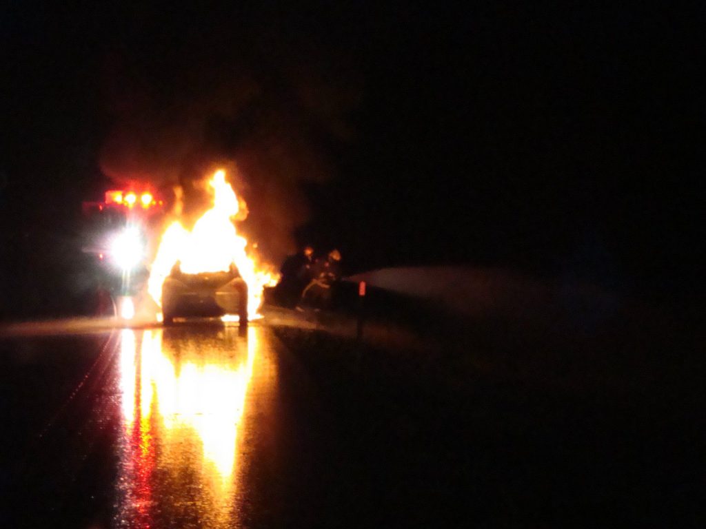 Electric vehicle on fire while driving at night.