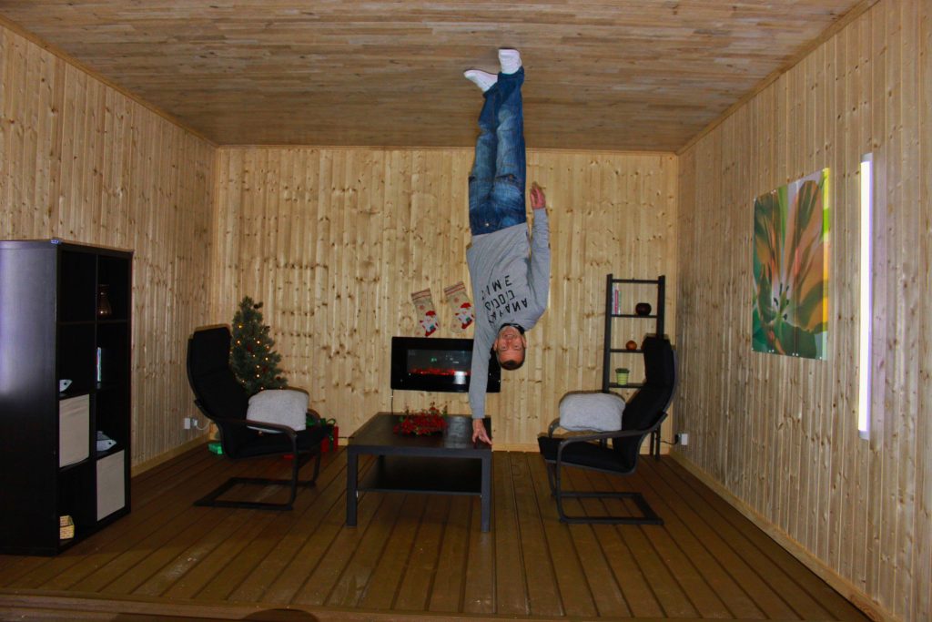 Man upside down in optical illusion house. 