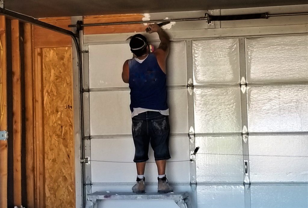 Man repairing garage door.