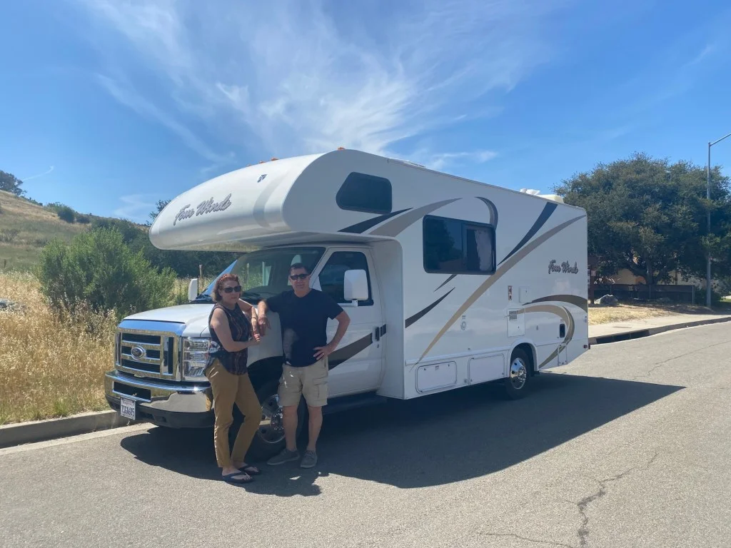 Couple standing together in front of RV