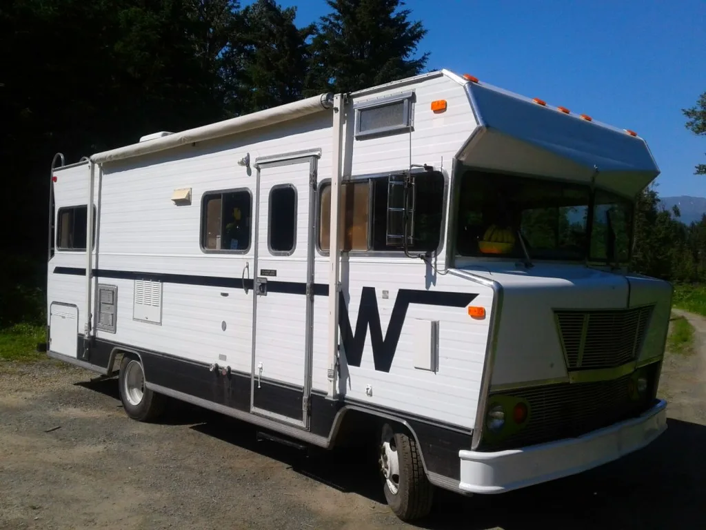 Vintage Winnebago camper parked at campsite.
