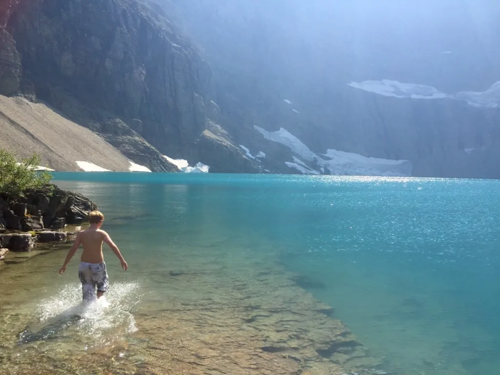 Boy swimming in lake in Glacier National Park.