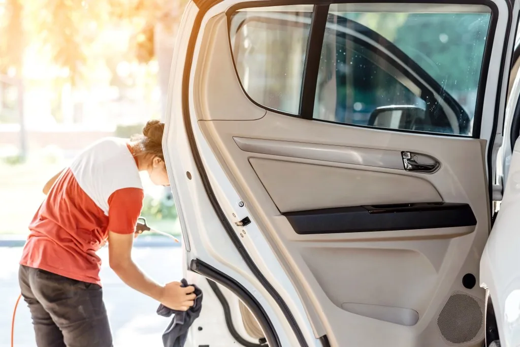 Woman applying a ceramic coating to a vehicle.