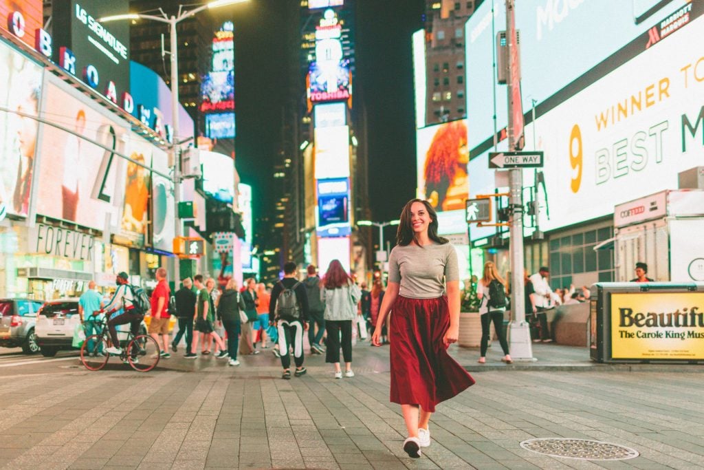 Woman smiling in Times Square for photo.