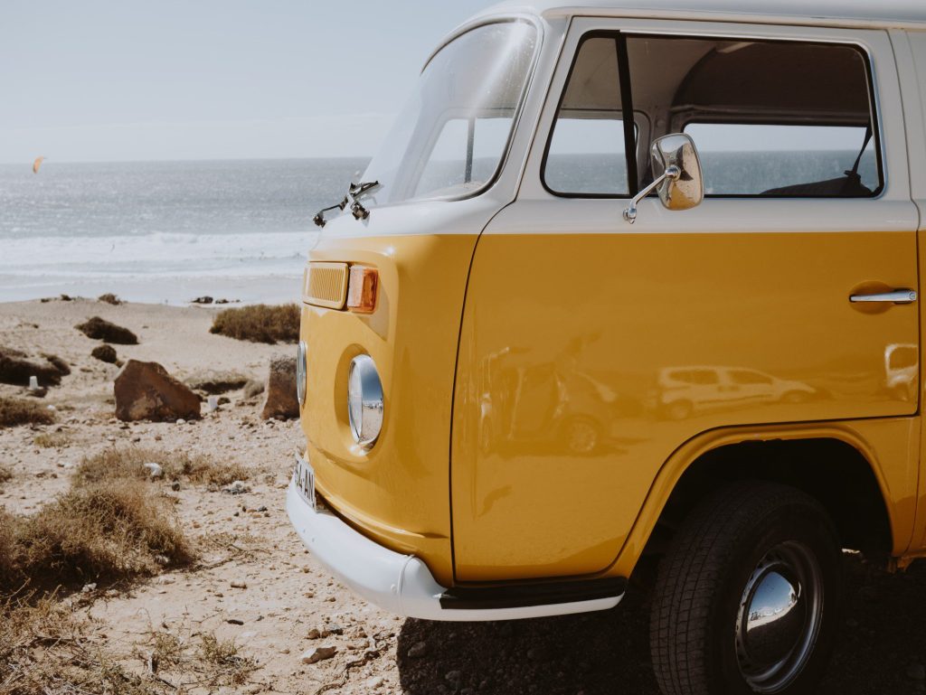 Yellow Volkswagen camper van RV parked on beach