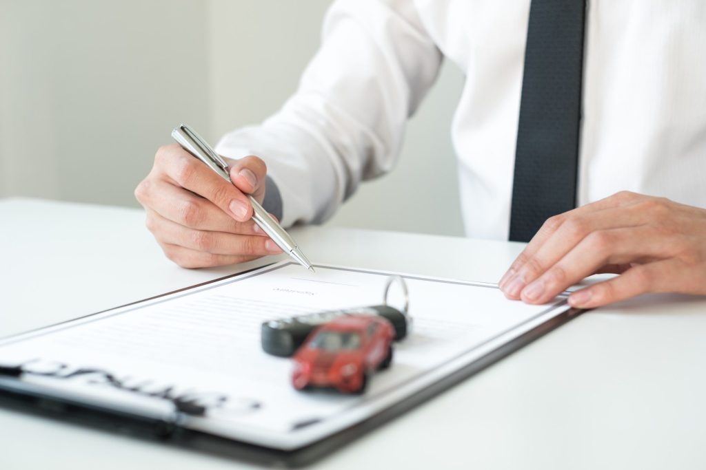 Person signing contract in dealership to get keys