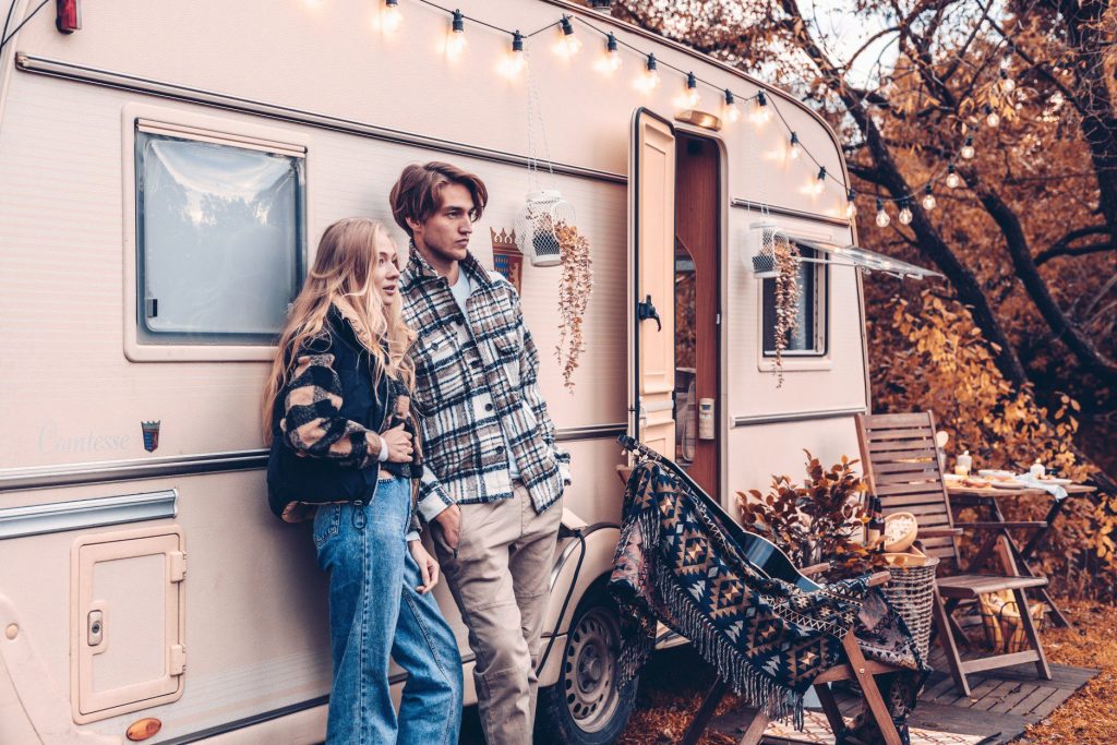 Couple posing together in front of travel trailer