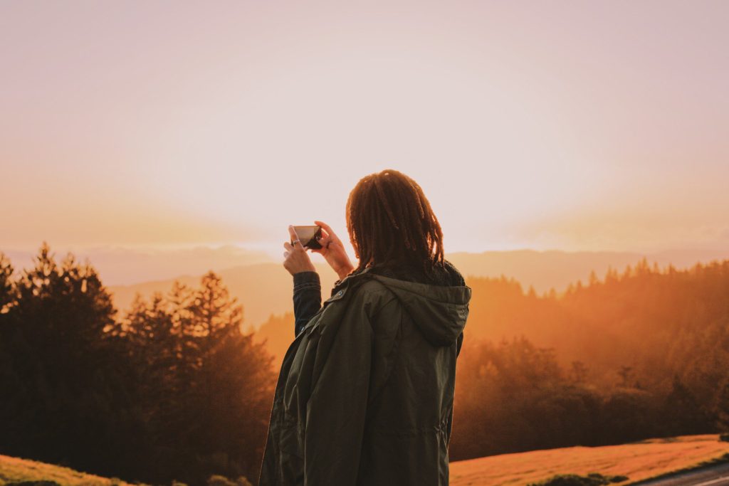Woman drinking coffee while watching sunrise in Northern California.