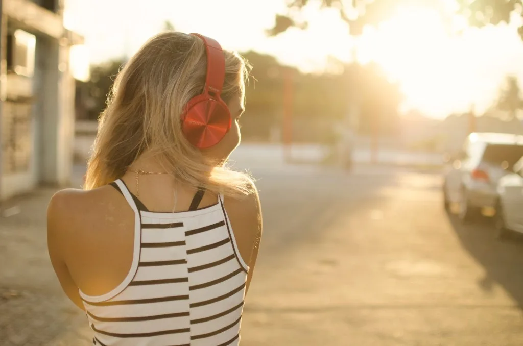 Woman listening to music in red headphones.