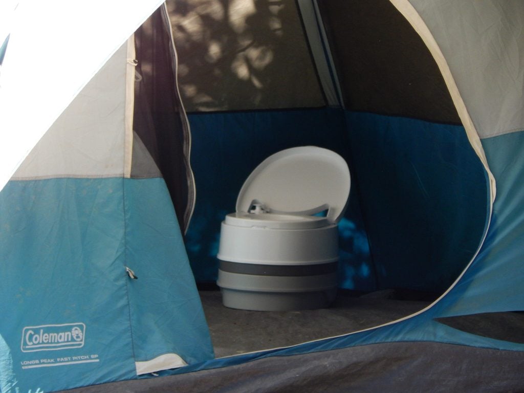 Interior of tent with portable camping toilet inside