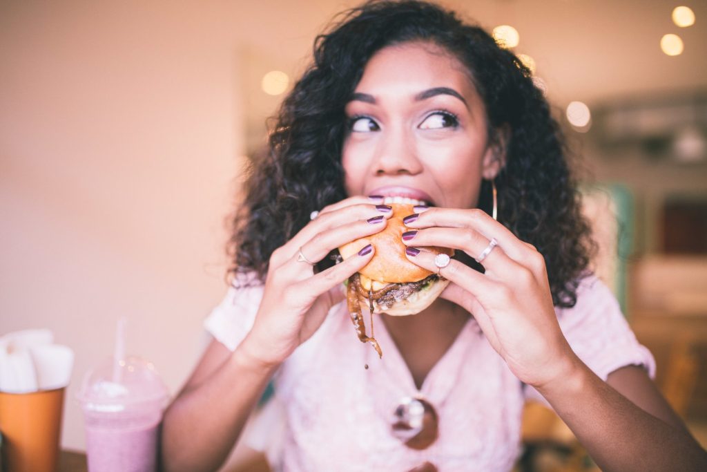 Woman eating burger in a restaurant