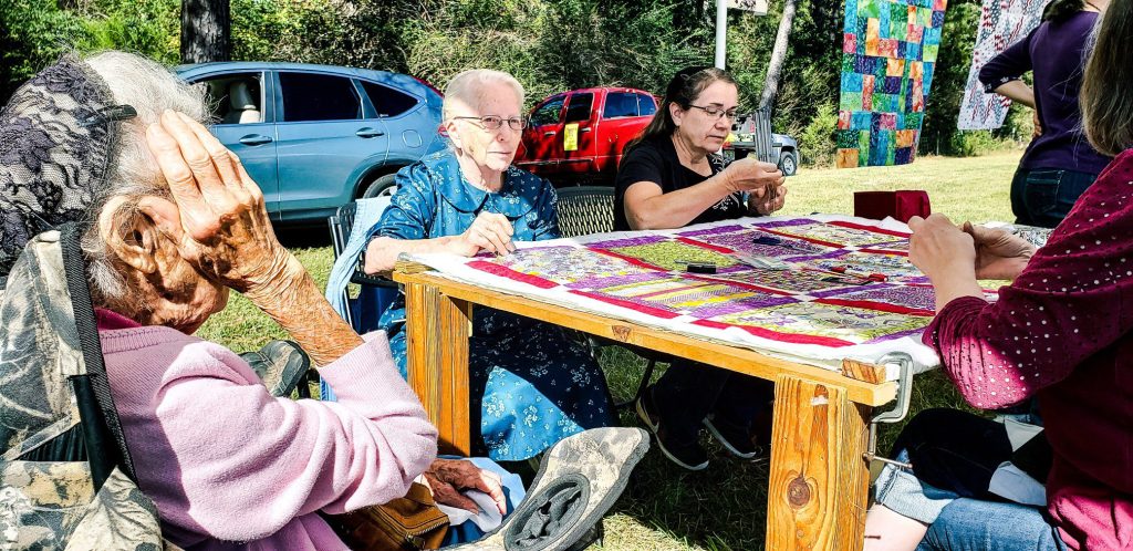 Older group of artistis quilting together at the Minnie Adkins Day Folk Art Festival