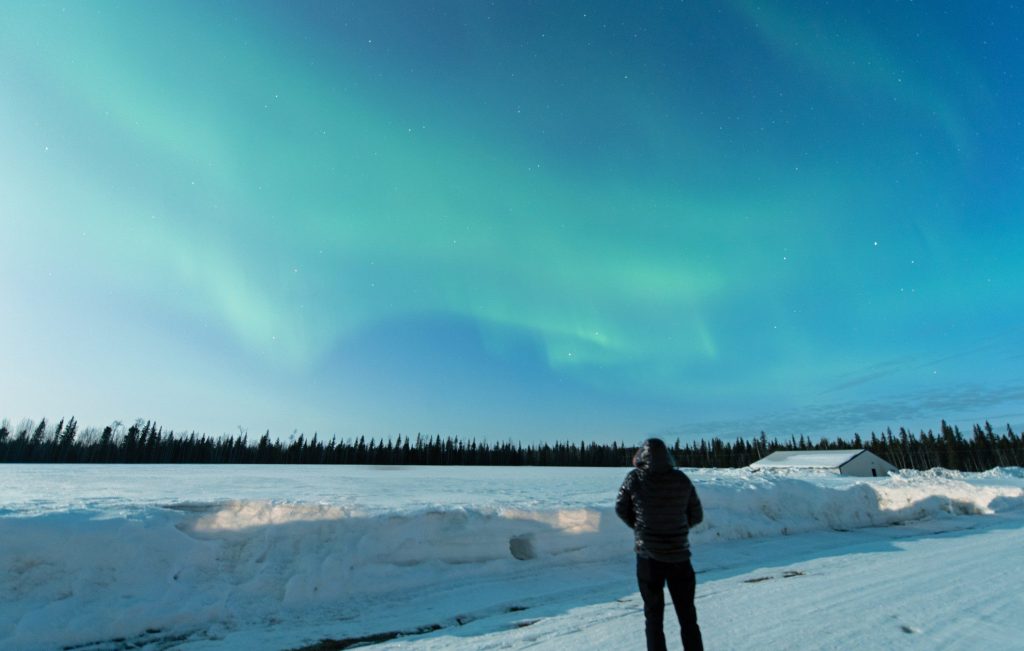 Man looking at Northern Lights in Alaska