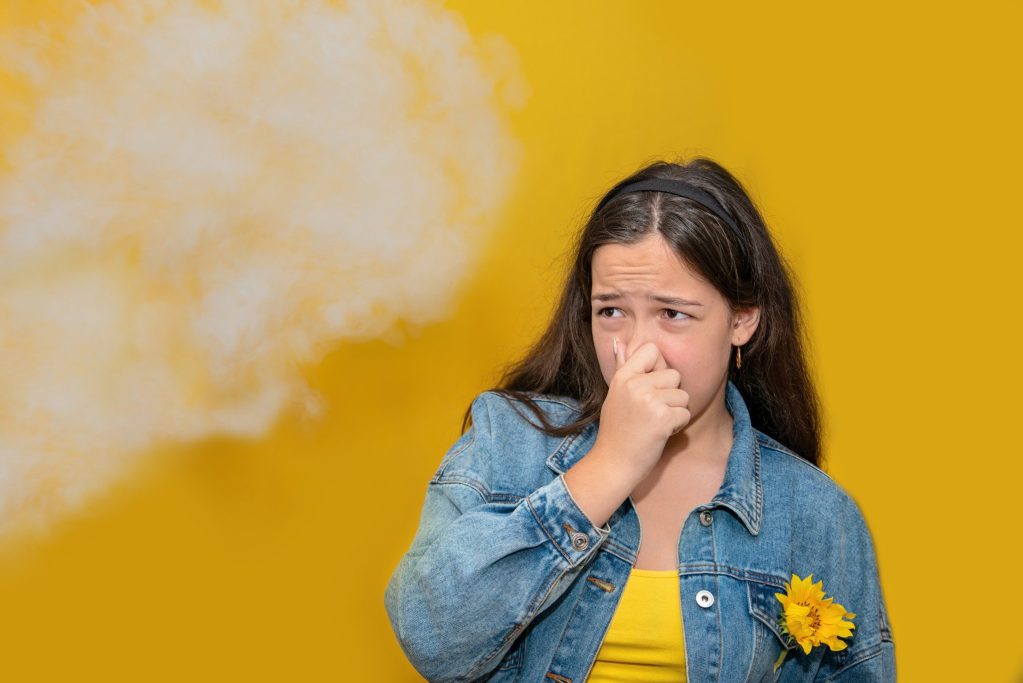 Girl pinching her nose from a bad odor