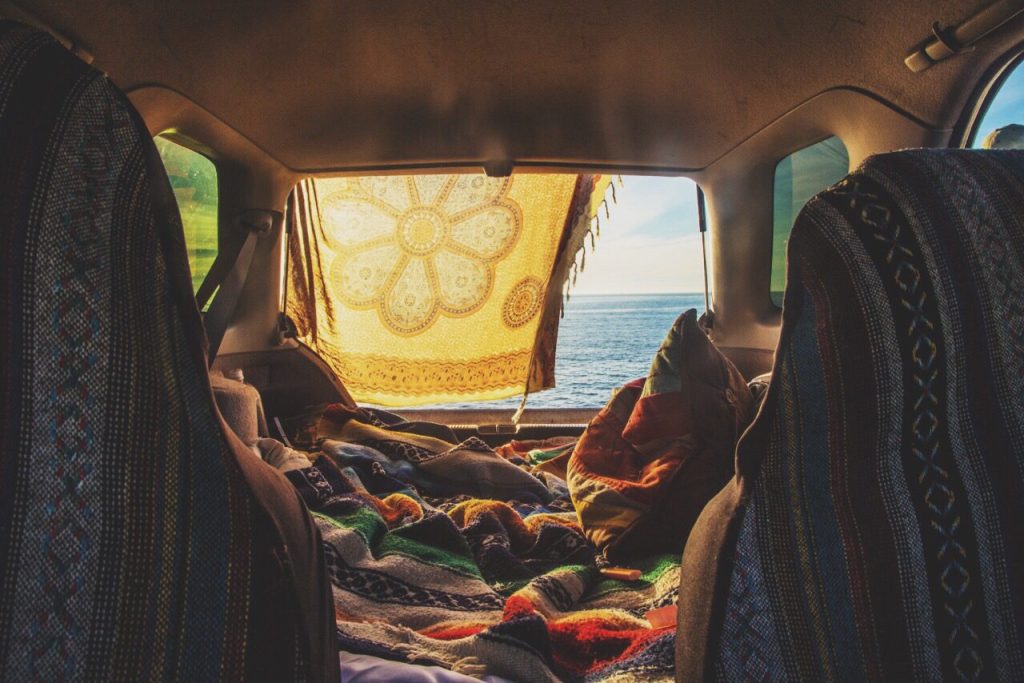 Interior of car where woman is car camping next to the beach