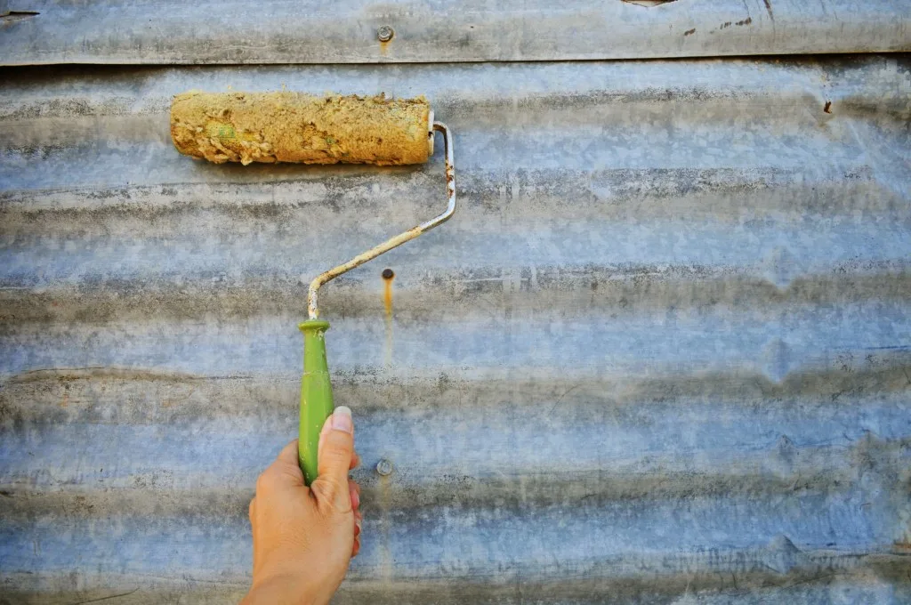 Woman painting metal garage door