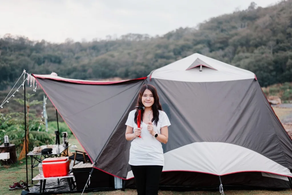 Girl standing in front of tent at KOA campground