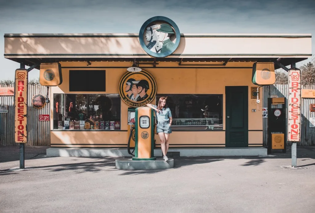 Woman posing at vintage gas station