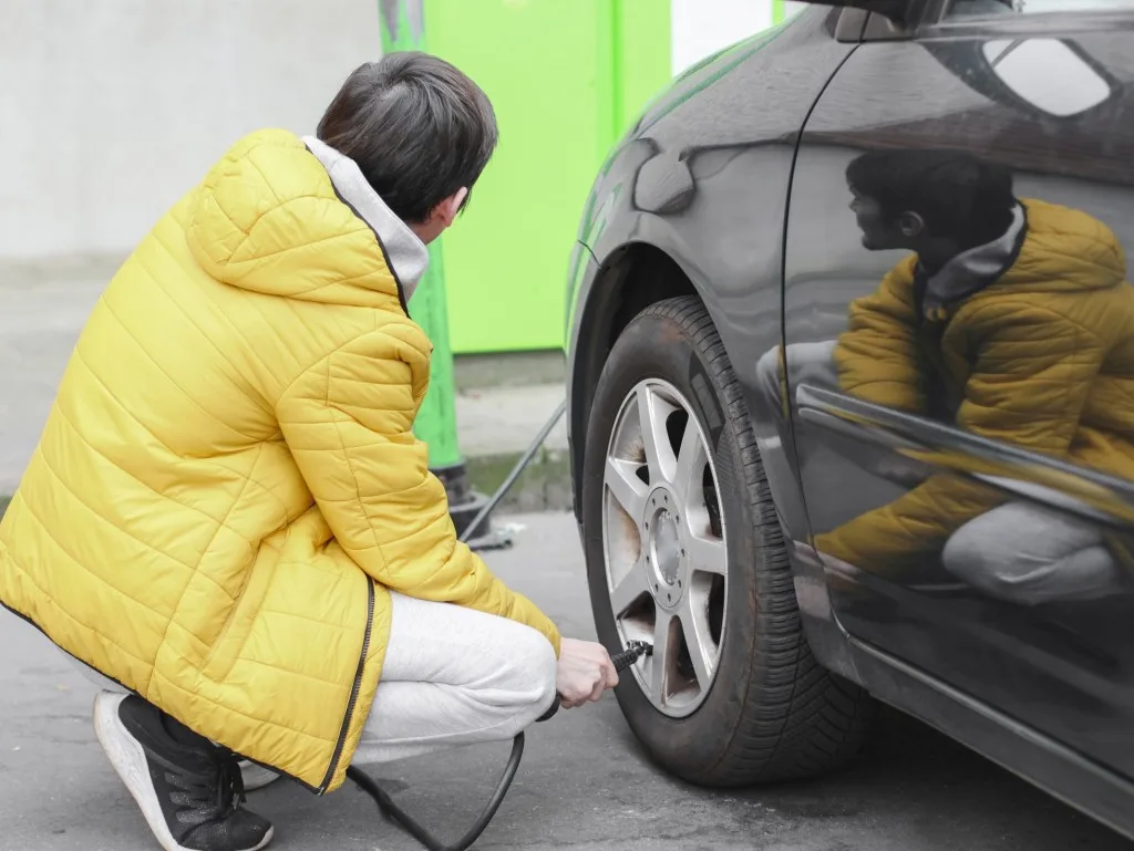Man inflating car tire