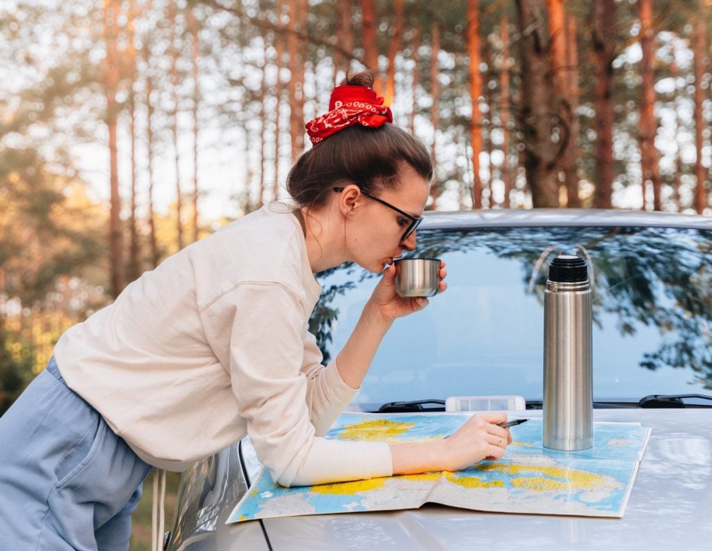 Woman reading map while car camping