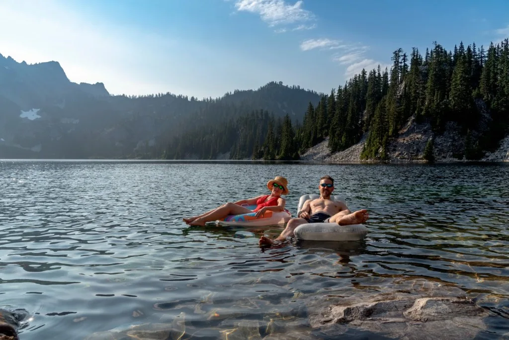 Couple sitting in innertubes on Ross Lake