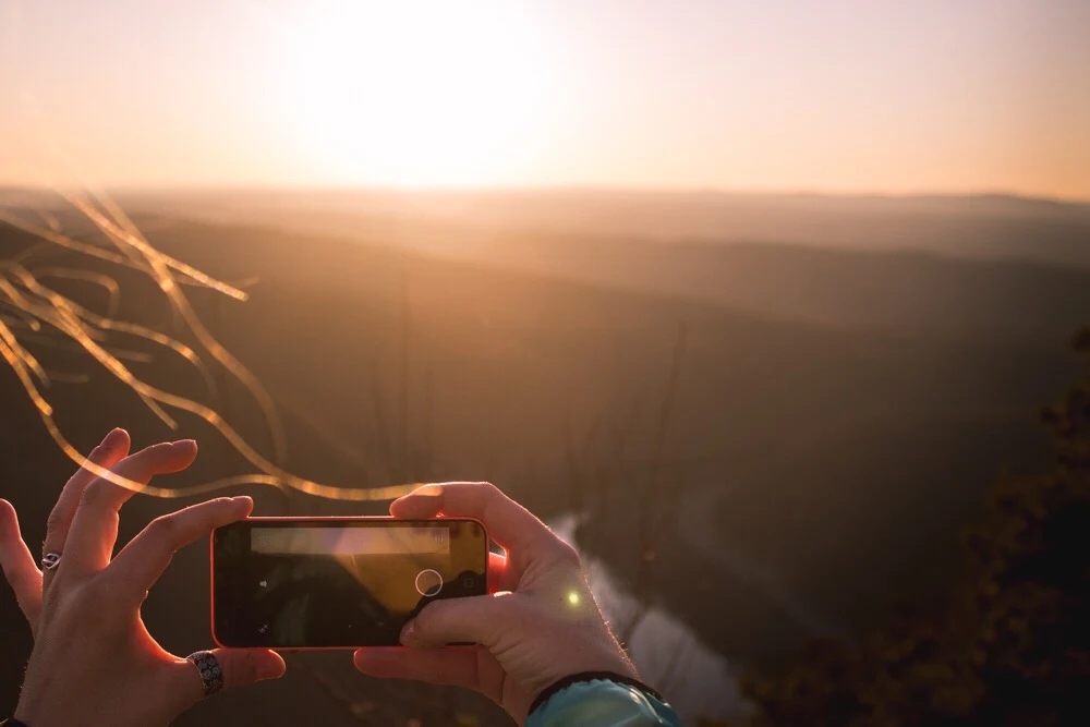 Woman taking photo of sunset in the  Delaware Water Gap National Recreation Area
