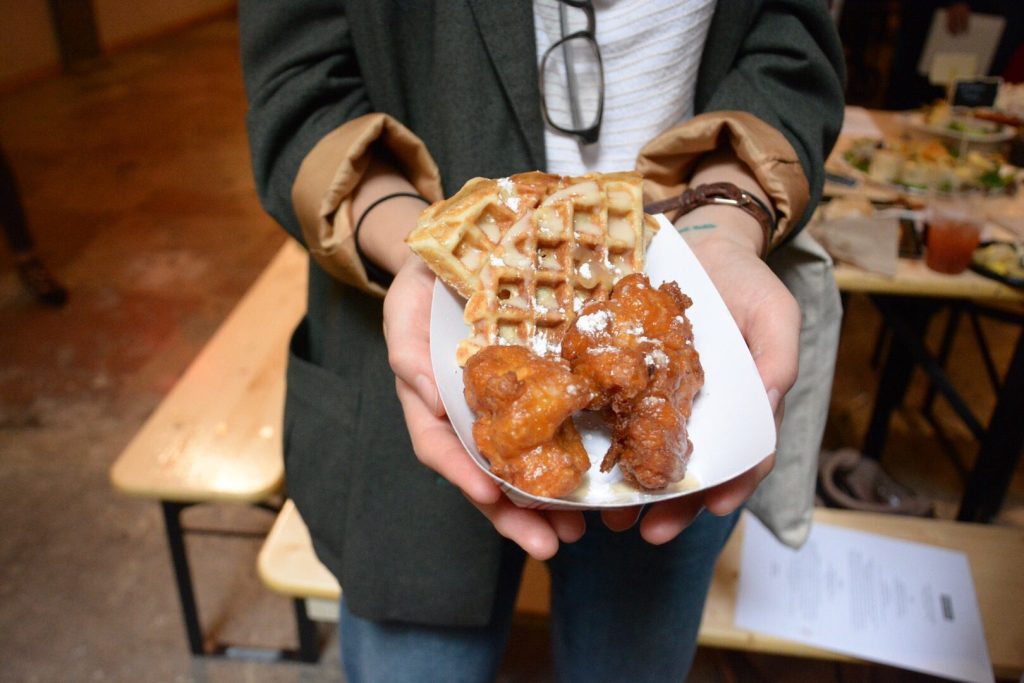 Woman holding chicken and waffles