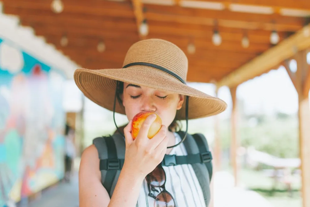 Woman eating peach