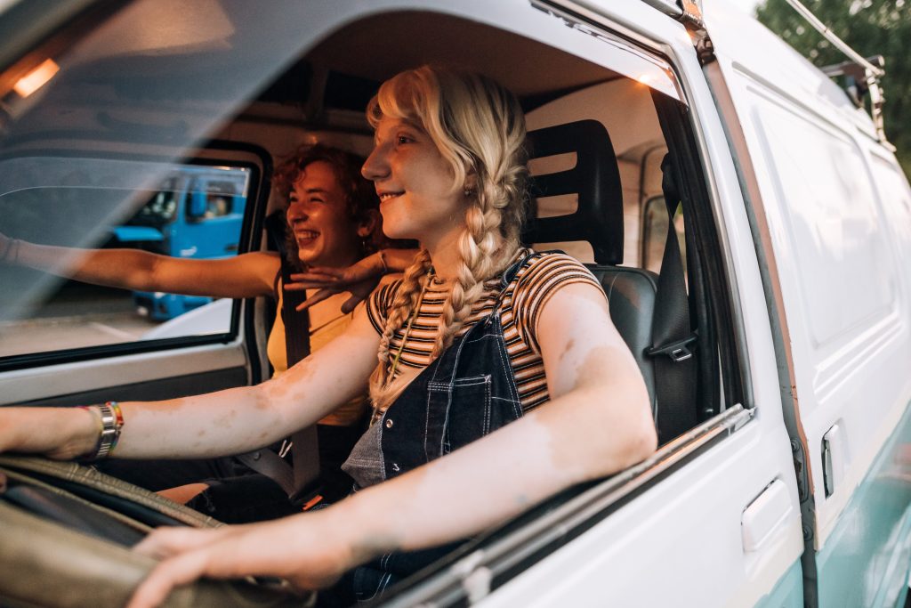 Two female friends driving camper van 
