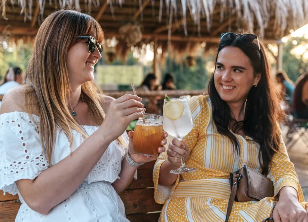 Two woman cheersing while at Happy Hour.