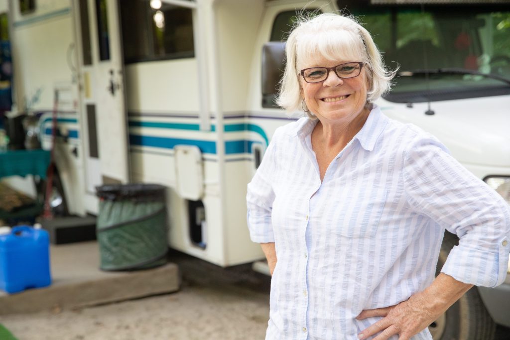 Older woman smiling in front of RV