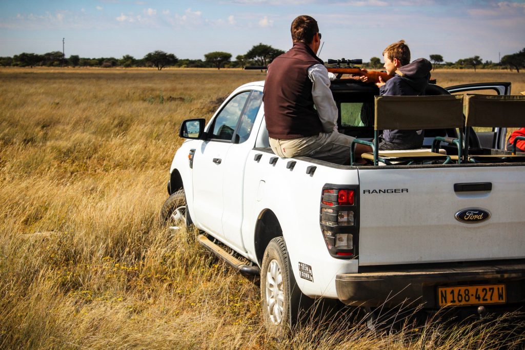 Father and son sitting in Ford Ranger truck bed while hunting together.