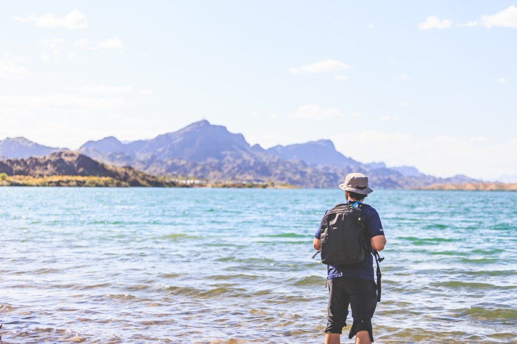 Man with hiking backpack looking out at Lake Mead