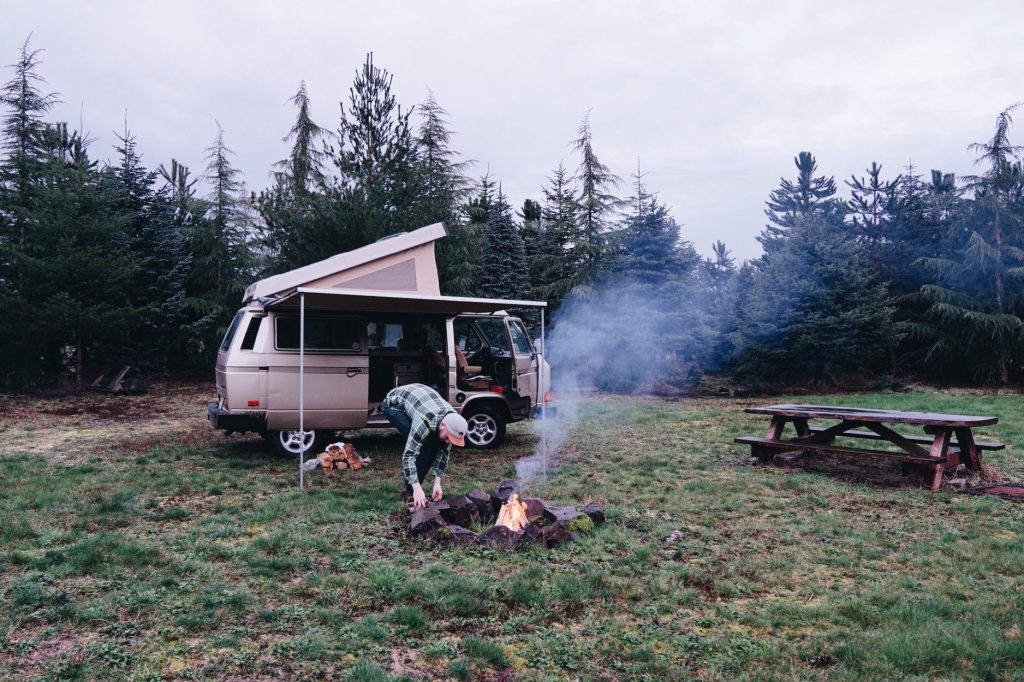 Man making campfire while boondocking in camper van