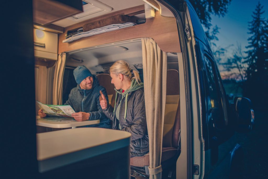 Couple planning RV camping trip at night time