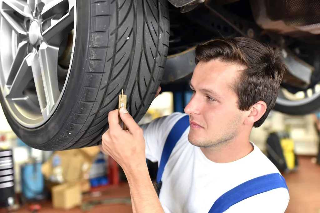 Mechanic checking tire tread