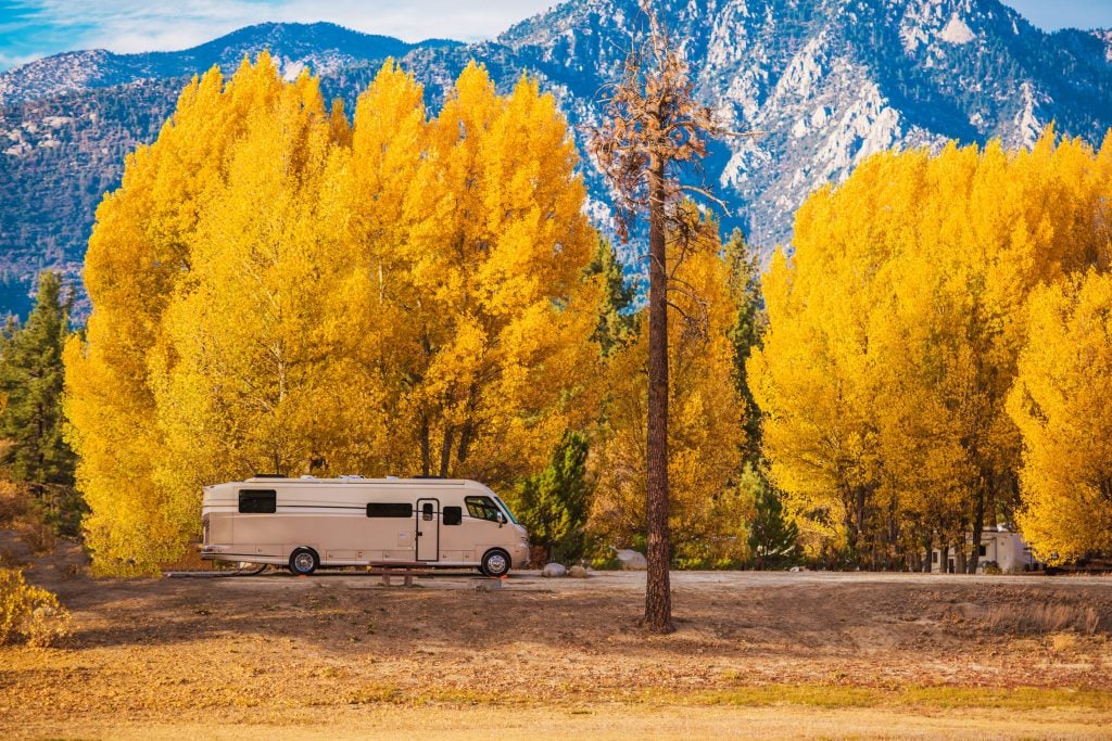 RV parked in camping lot in the fall. 