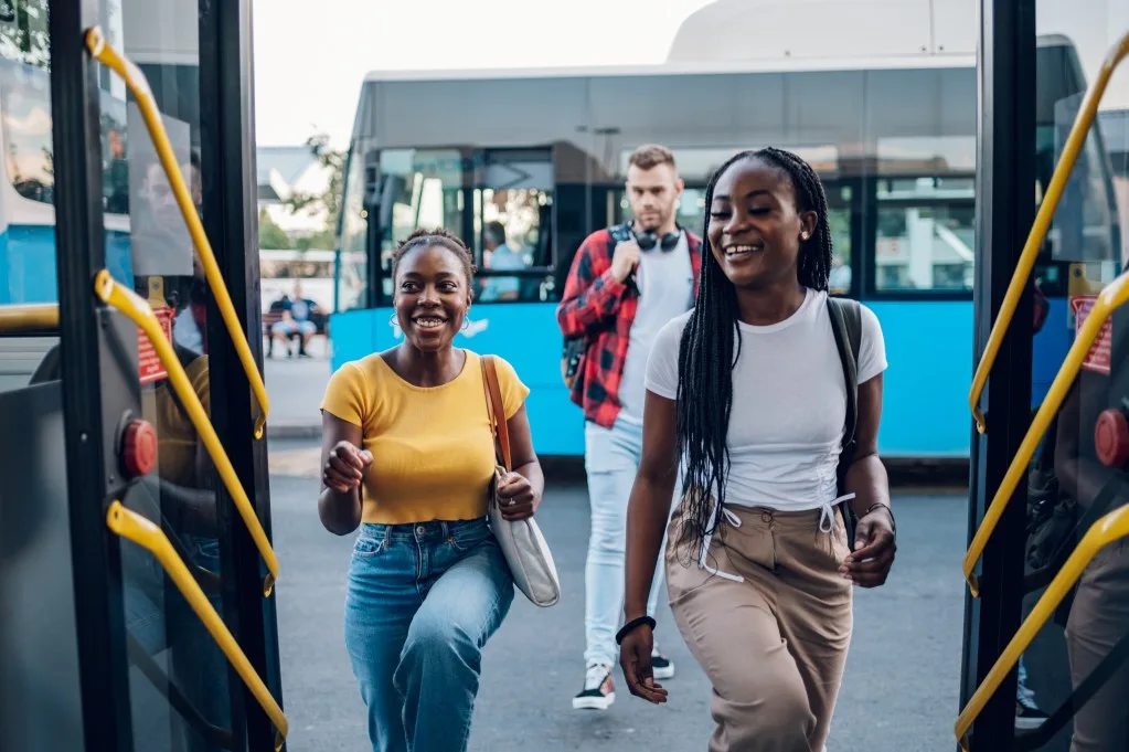 Friends getting on the bus to travel