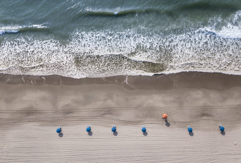 Straight down aerial view of beach and ocean waves in Myrtle Beach, South Carolina.