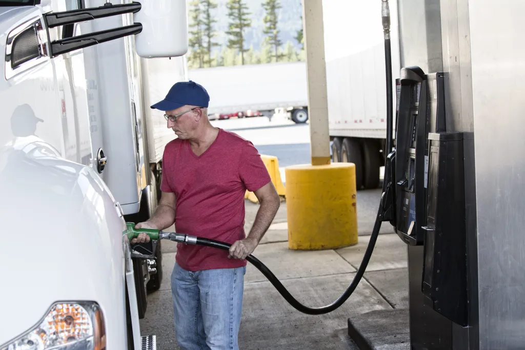 Trucker filling up gas tank at truck stop