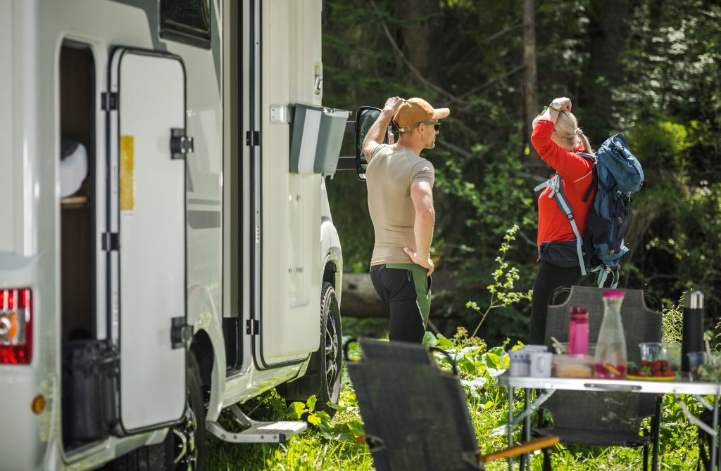 Couple getting ready for a hike next to RV