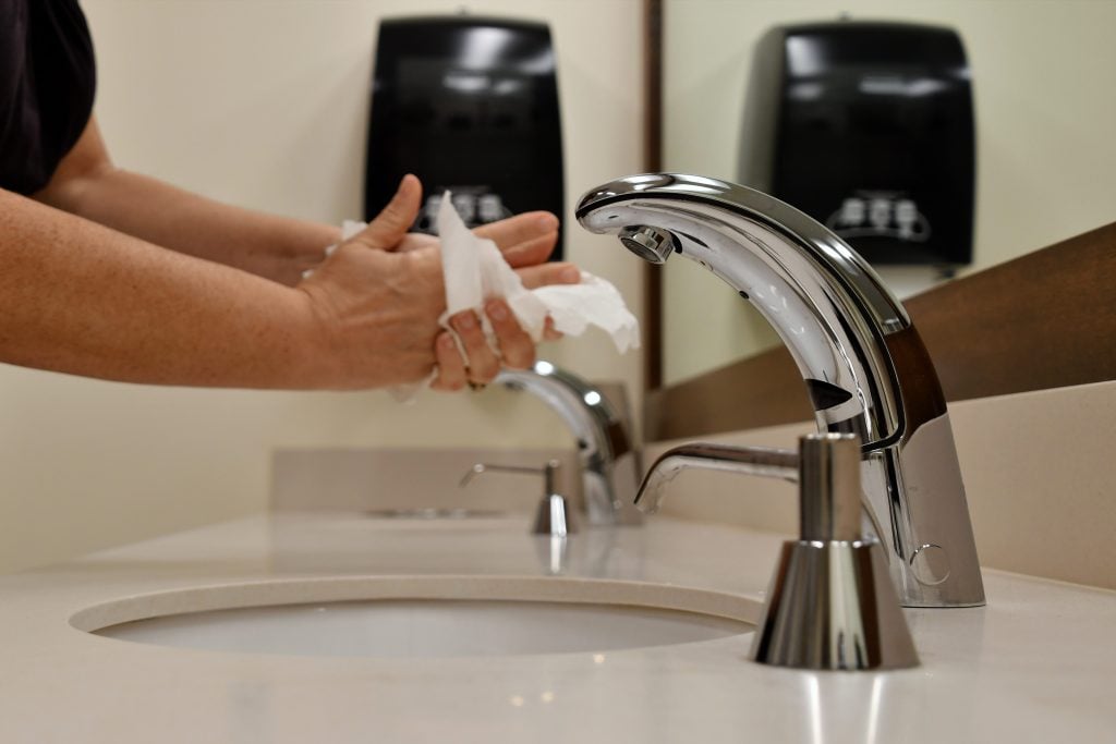 Woman washing her hands in a public restroom