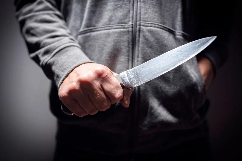 Criminal holding knife threateningly.