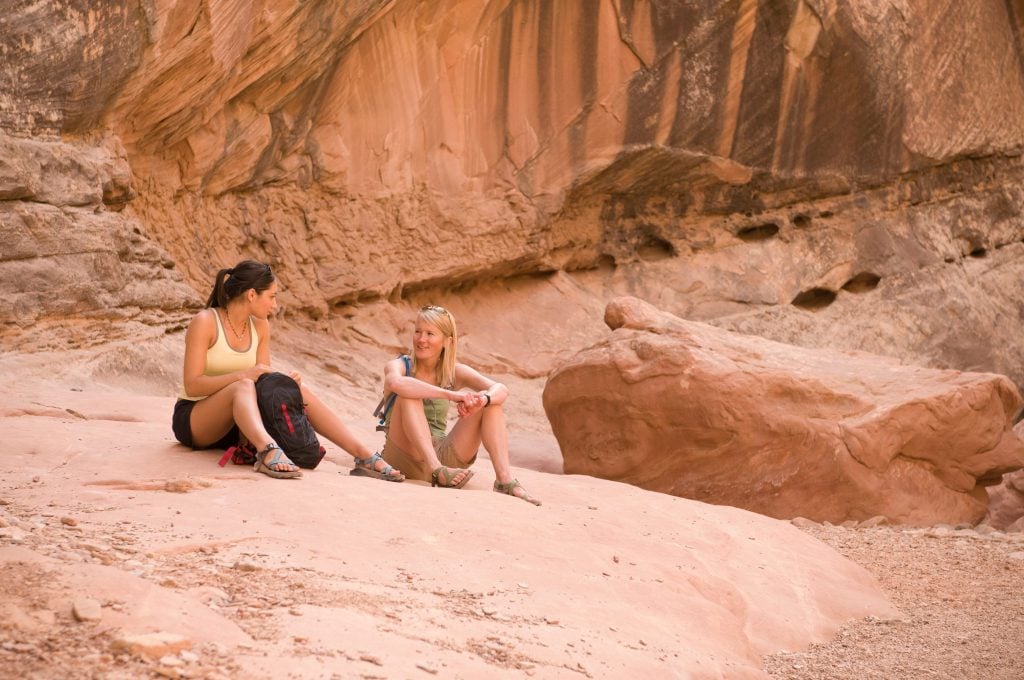Two women resting on a rock while hiking in Red Lake Reservation